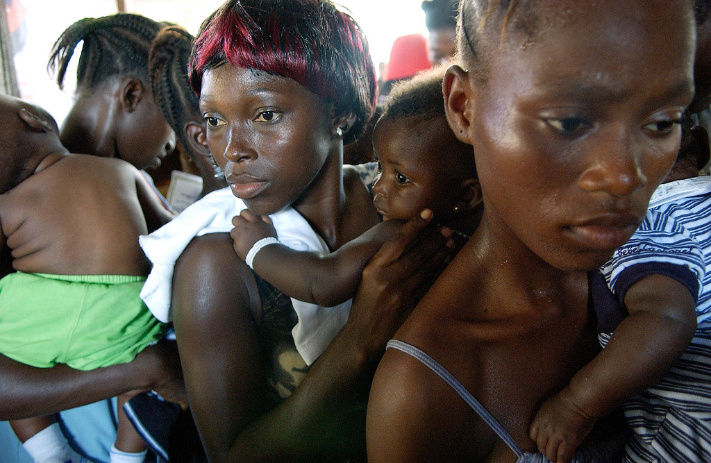 Mothers Wait with Children to Receive Polio Vaccination