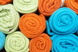 Pile,Of,Colorful,Blankets,Made,From,Fleece,,All,Rolled,Up.