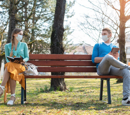 Woman,And,Man,In,Social,Distancing,Sitting,On,Bench,In