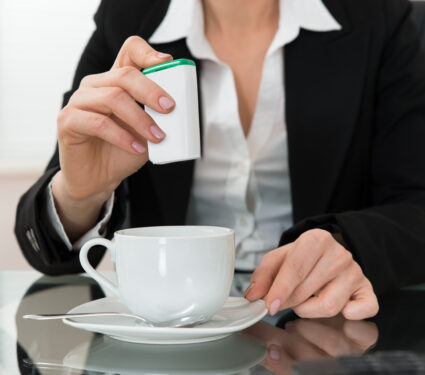 Close-up,Of,Young,Businesswoman,Putting,Sugar,In,Cup,At,Glass
