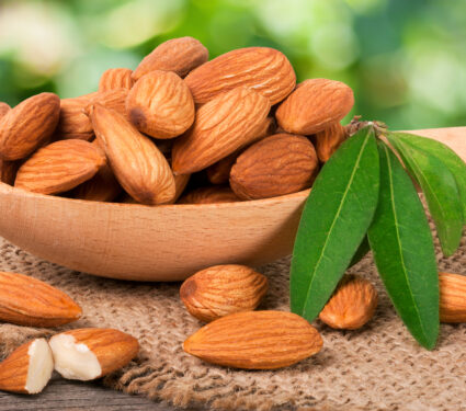 Heap,Of,Peeled,Almonds,With,Leaf,In,A,Wooden,Spoon