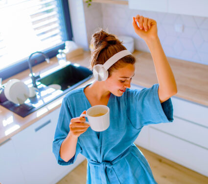Young,Woman,Listening,Music,And,Enjoying,Cup,Of,Coffee,At