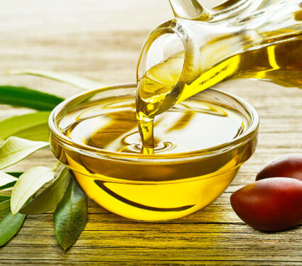 Bottle,Of,Olive,Oil,Pouring,In,A,Glass,Bowl,With