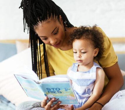 Beautiful,African,Woman,Sitting,On,Bed,And,Reading,A,Book