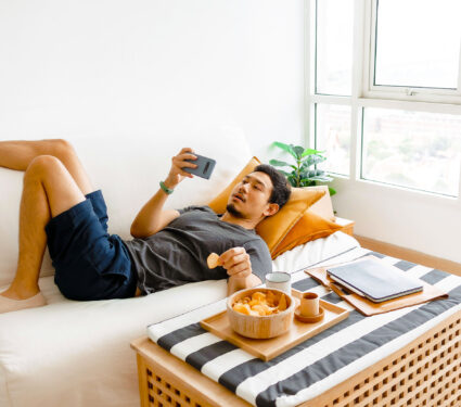 Asian,Man,Watch,Online,Tv,And,Eating,Snack,Instead,Of