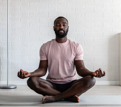 A,Young,African-american,Man,Is,Meditating,In,A,Bright,,Minimalist