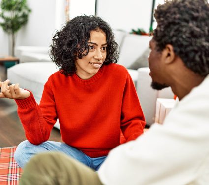 Young,Interracial,Couple,Smiling,Happy,And,Speaking,Sitting,On,The